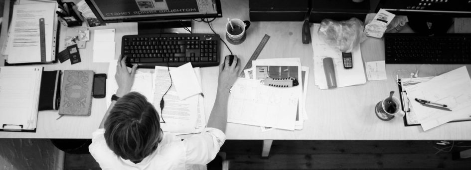 Mythos Multitasking - schwarz-weiß Foto eines vollen Schreibtisches